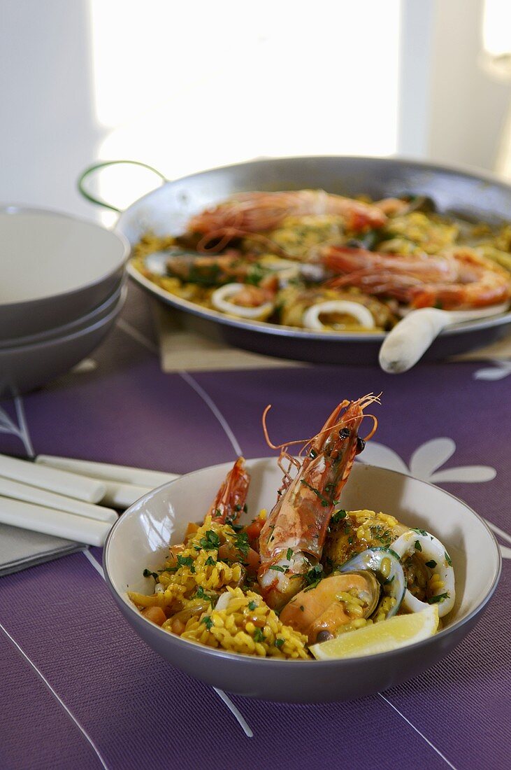 Paella in a dish and in a paella pan