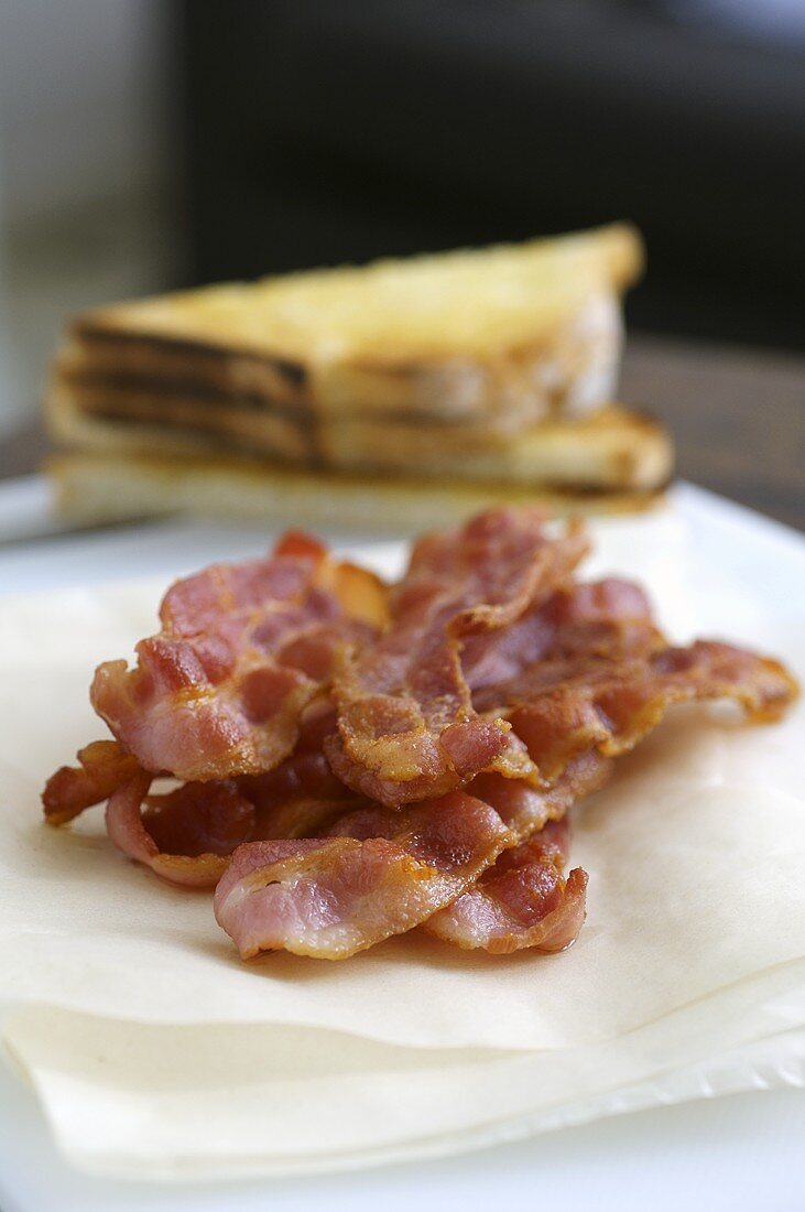 Gebratene Speckscheiben auf Küchenkrepp mit Toast