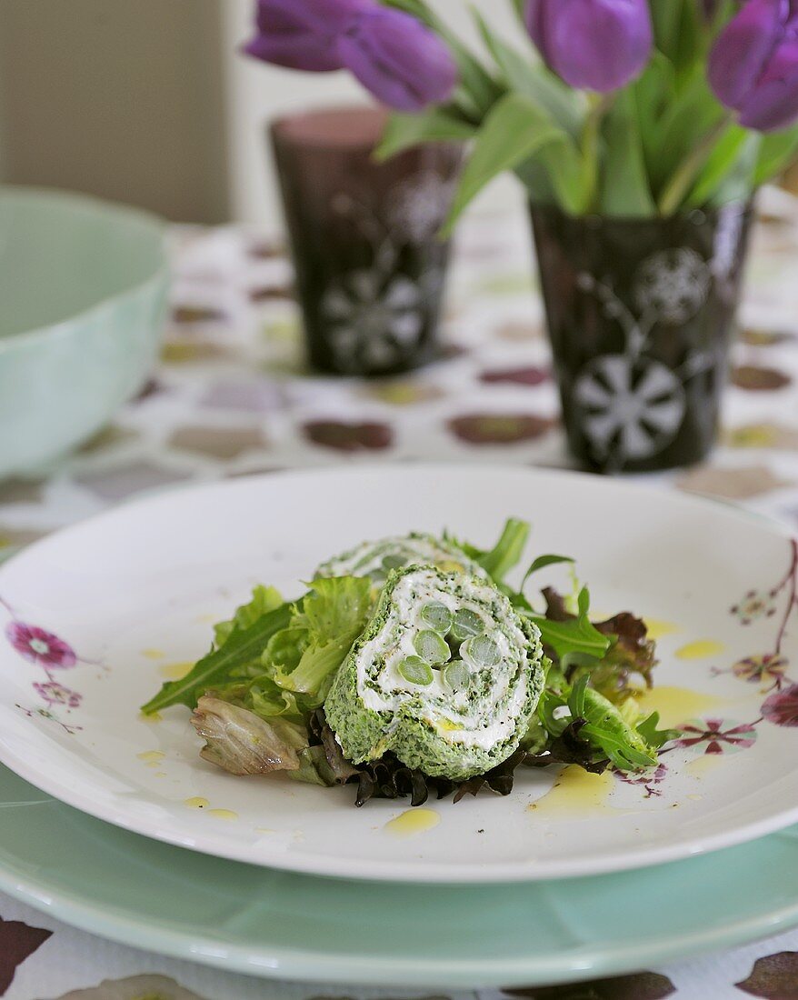 Soft cheese and asparagus roulade on salad leaves