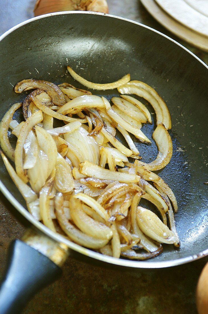 Lightly fried onions in a frying pan