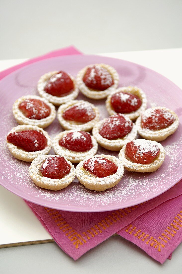 Strawberry and custard tartlets on a plate