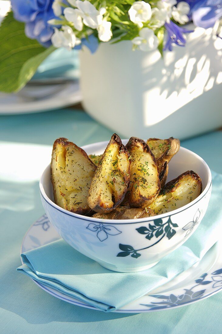 Potatoe Wedges mit Rosmarin in einer Schüssel im Freien