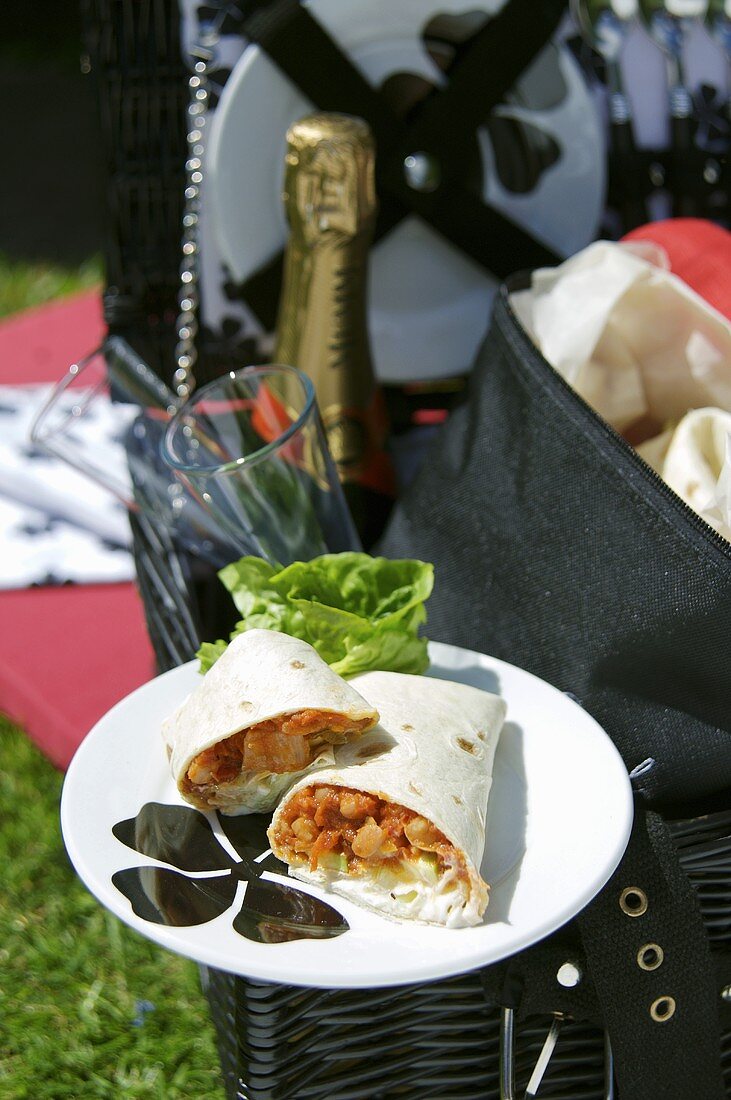 Wraps with beans & iceberg lettuce on picnic basket out of doors