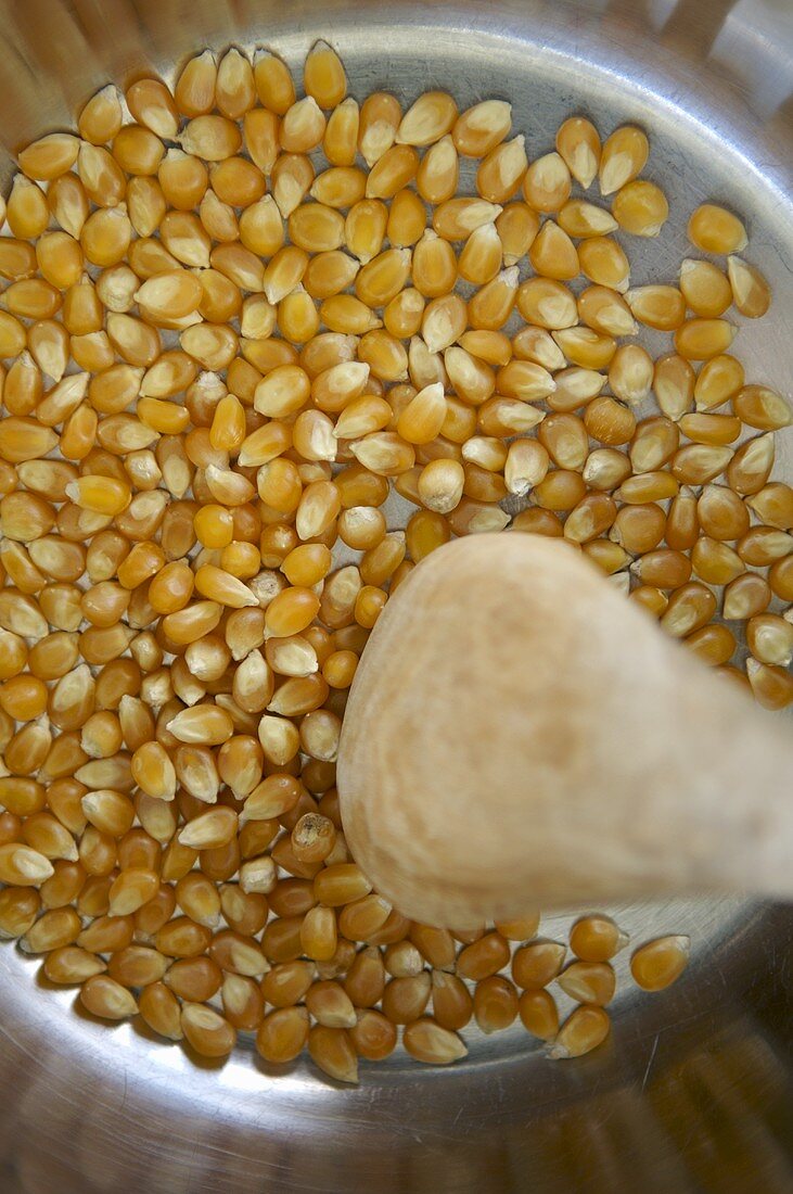 Making popcorn: stirring corn kernels in a pan