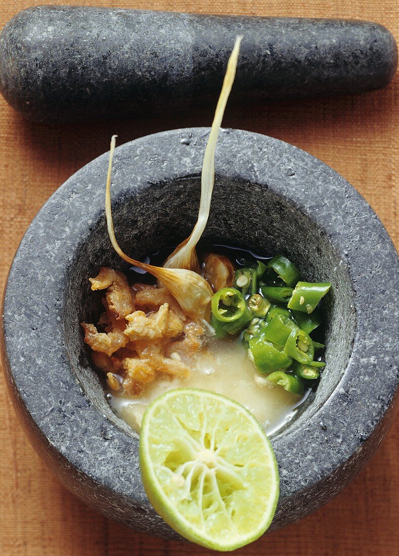 Ingredients for prawn sauce in a stone mortar