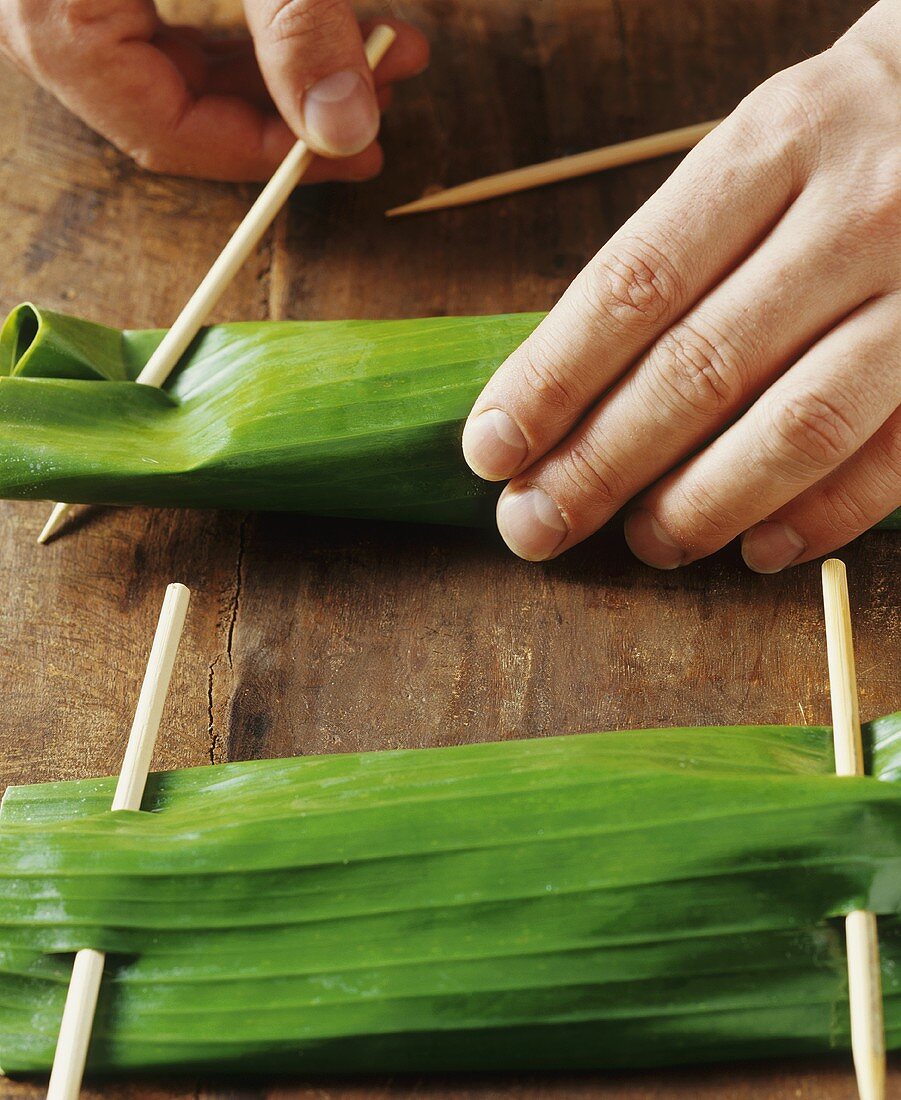 Securing banana leaves stuffed with red snapper