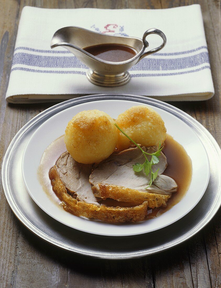 Spanferkel-Krustenbraten mit Kartoffelknödeln und Biersauce