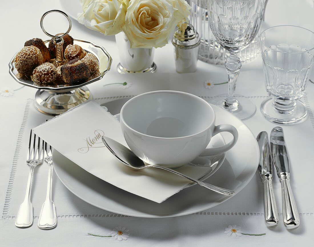 An elegant place-setting with menu and white roses