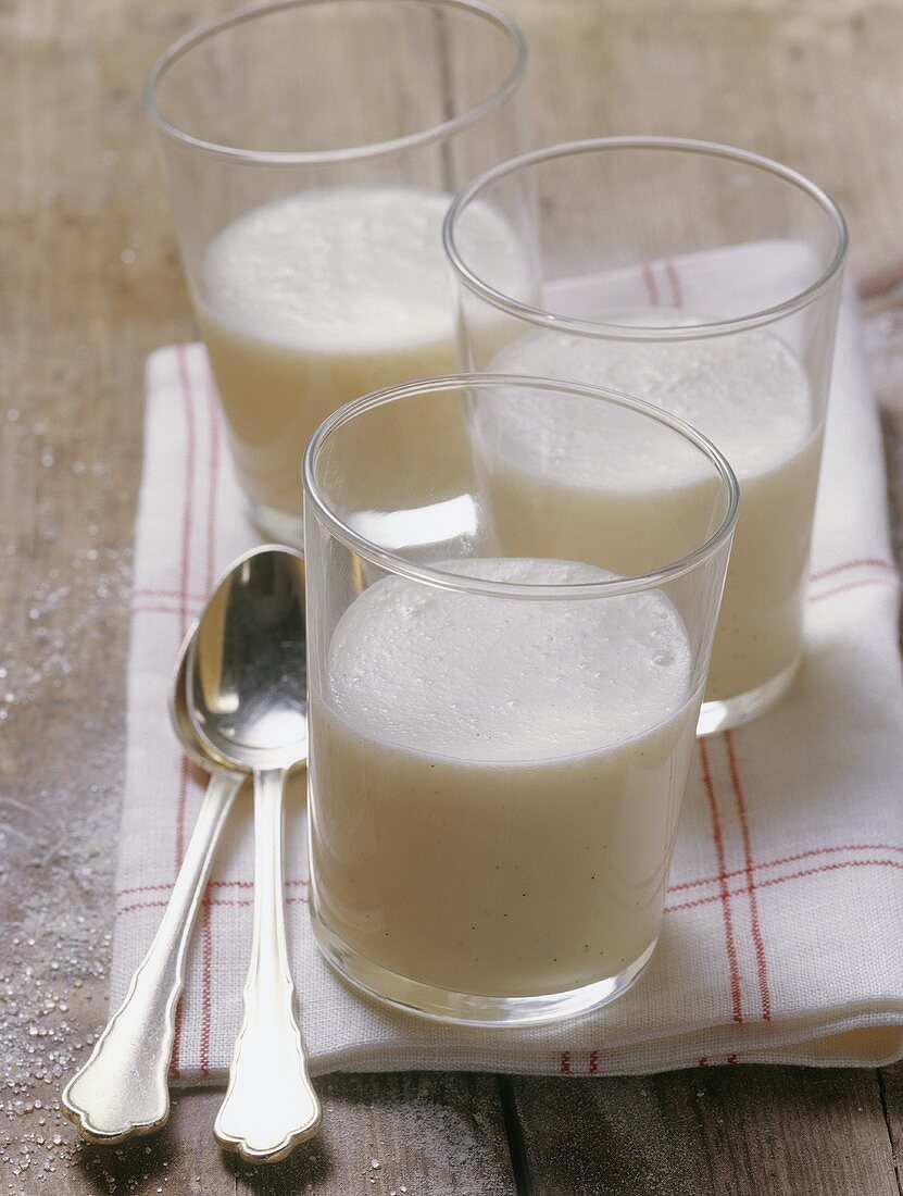 Buttermilch in drei Gläsern auf einem Küchentuch mit Löffeln