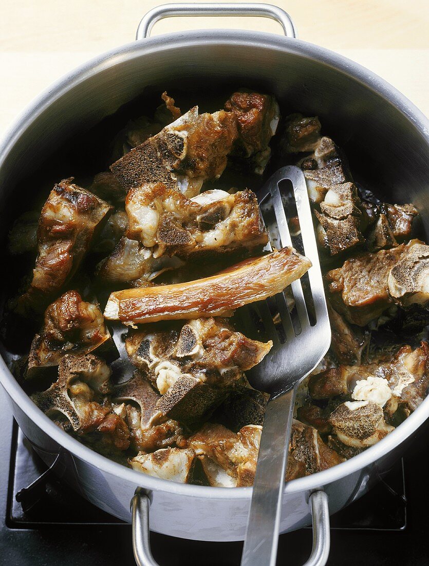Fried veal bones in a pan, to make veal stock