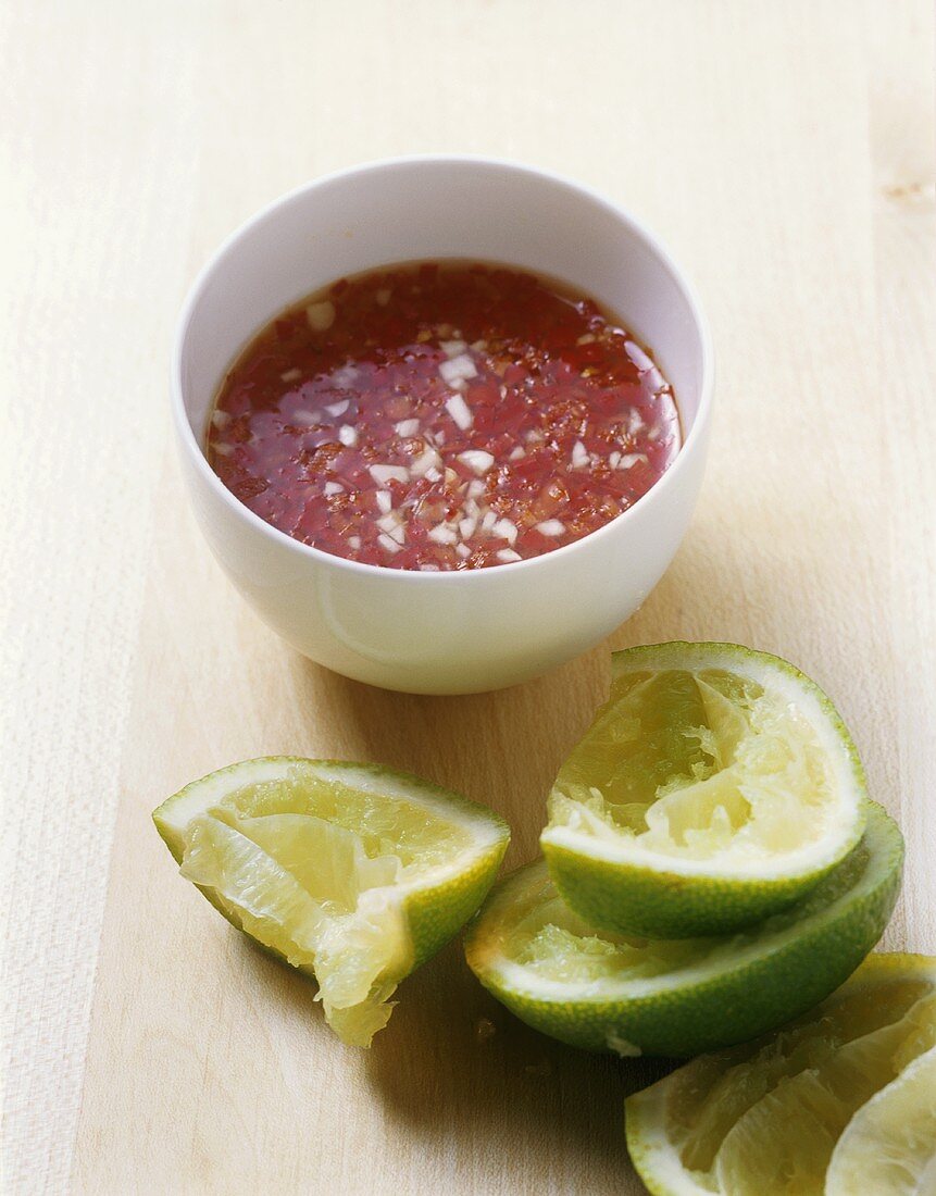 Chilli sauce in a bowl with squeezed lime