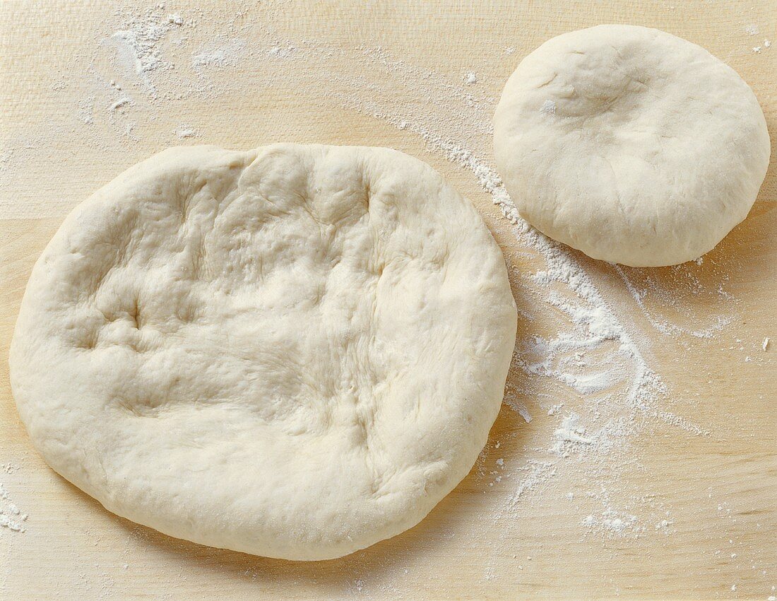 Pizza dough on floured work surface