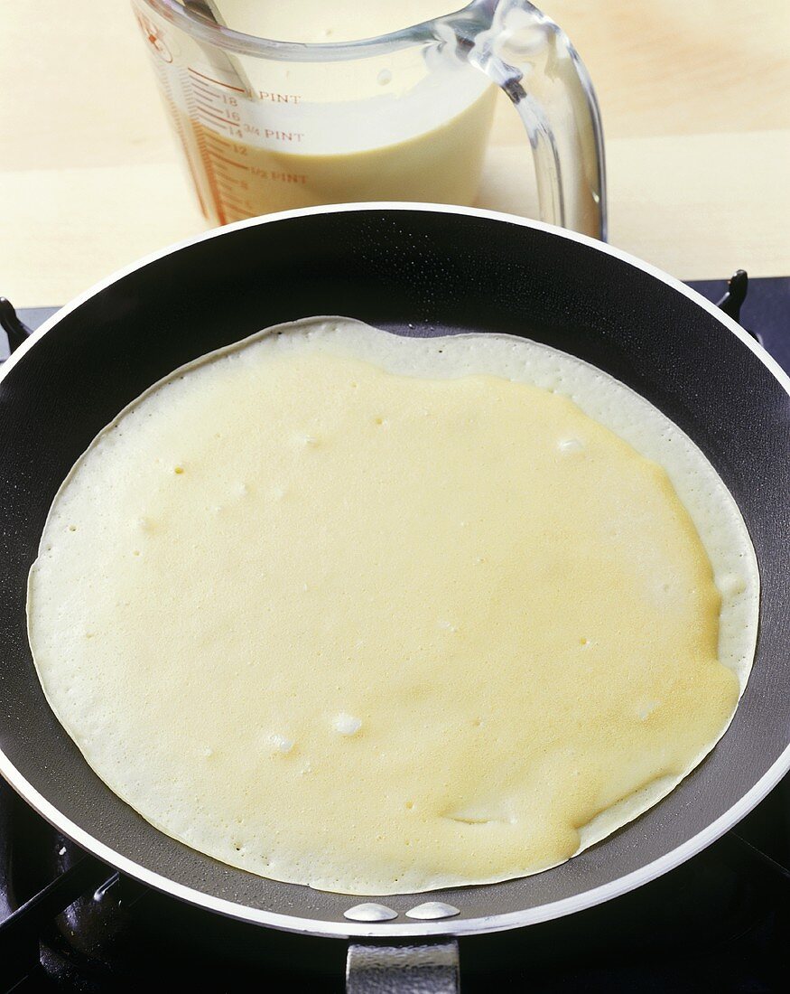 Pancake being fried in a frying pan