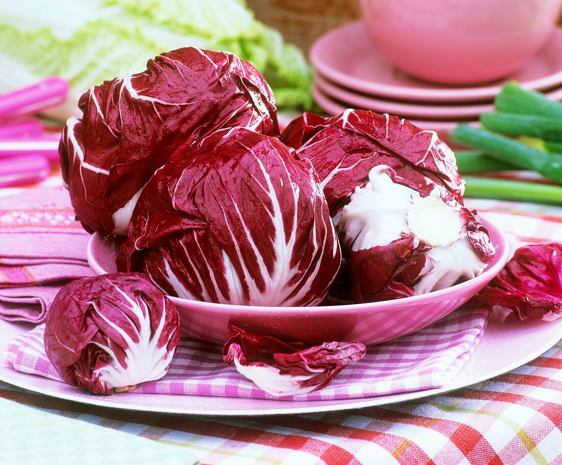 Mehrere Radicchio-Köpfe auf Servietten und Tellern