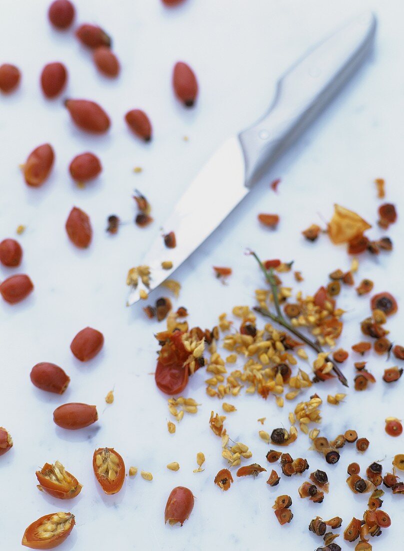 Whole and seeded rose hips with knife and seeds