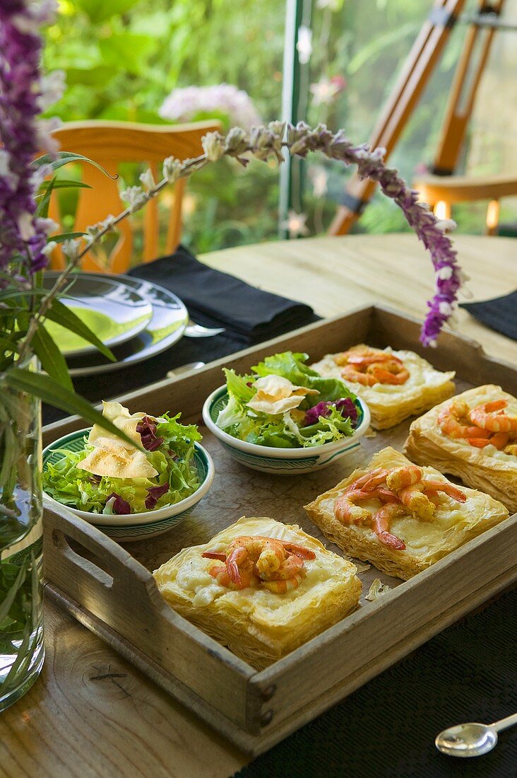 Puff pastry slices with prawns, green salads on tray