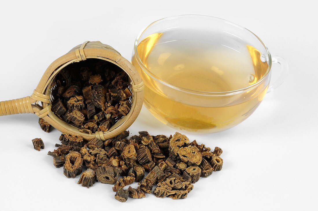 Pieces of dried gentian root with tea strainer and tea