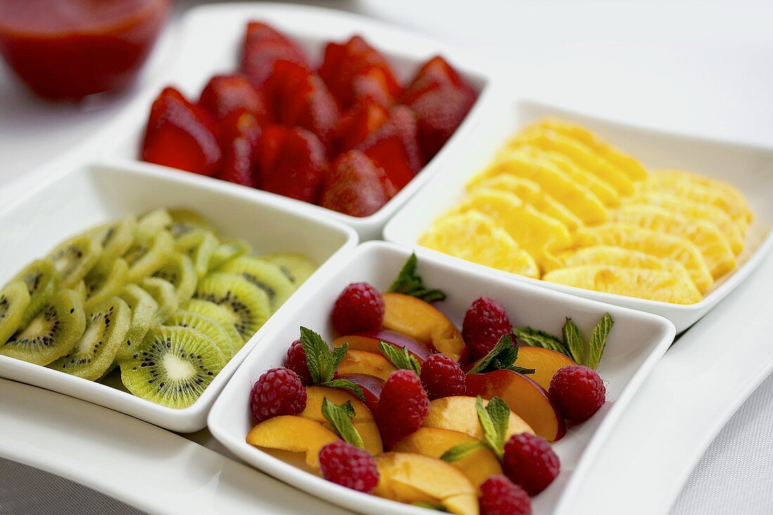 Dishes of different sliced fruits for breakfast