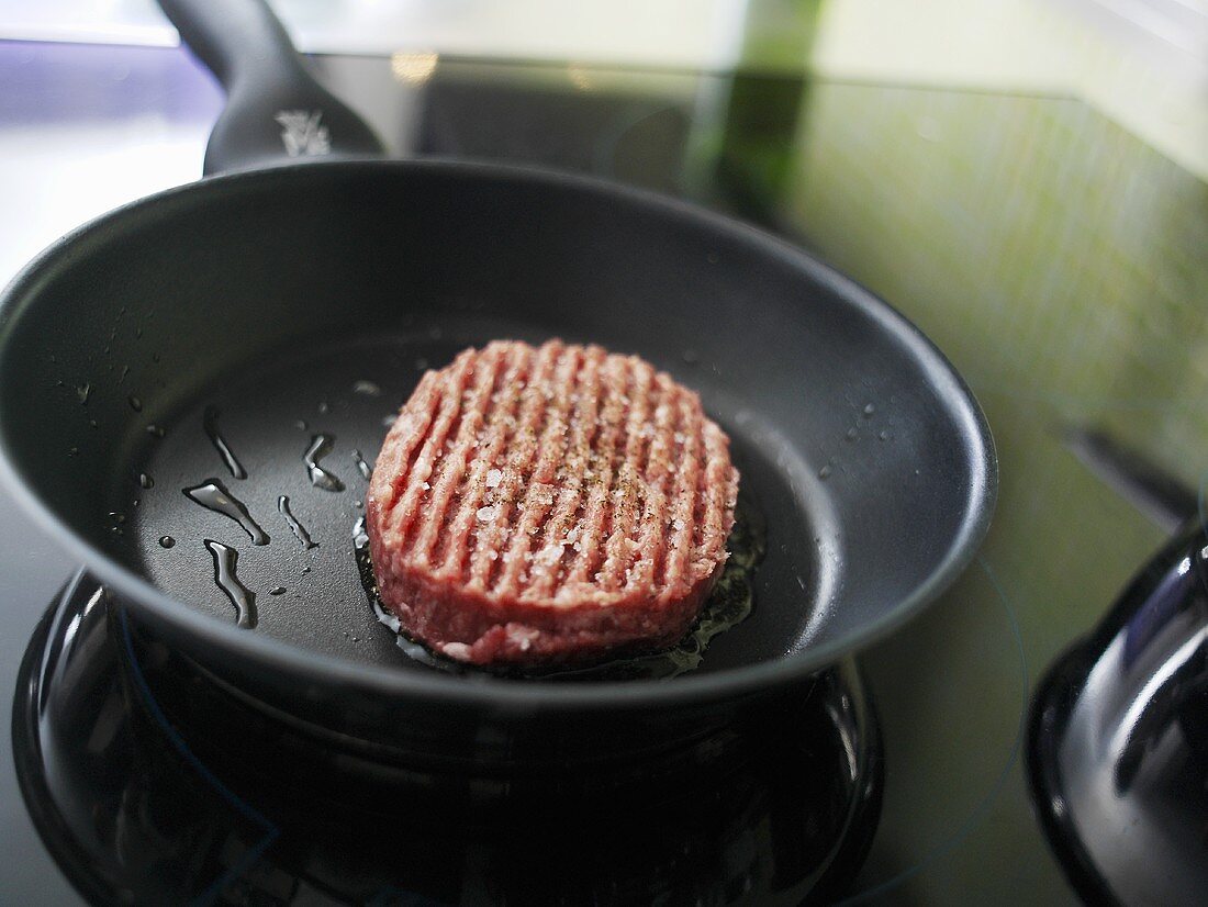 Burger frying in a frying pan