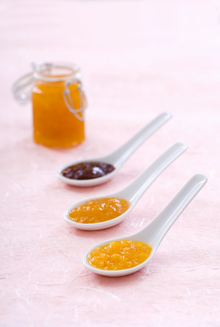 Strawberry and apricot jam, orange marmalade on spoons