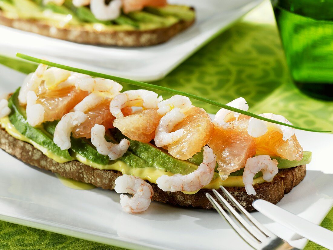 Avocado, grapefruit and shrimps on toasted bread