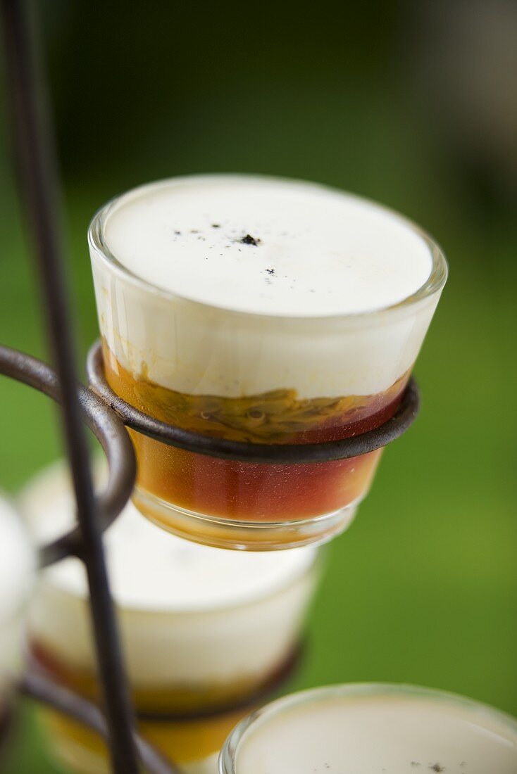 Panna cotta on passion fruit puree in glasses on a stand