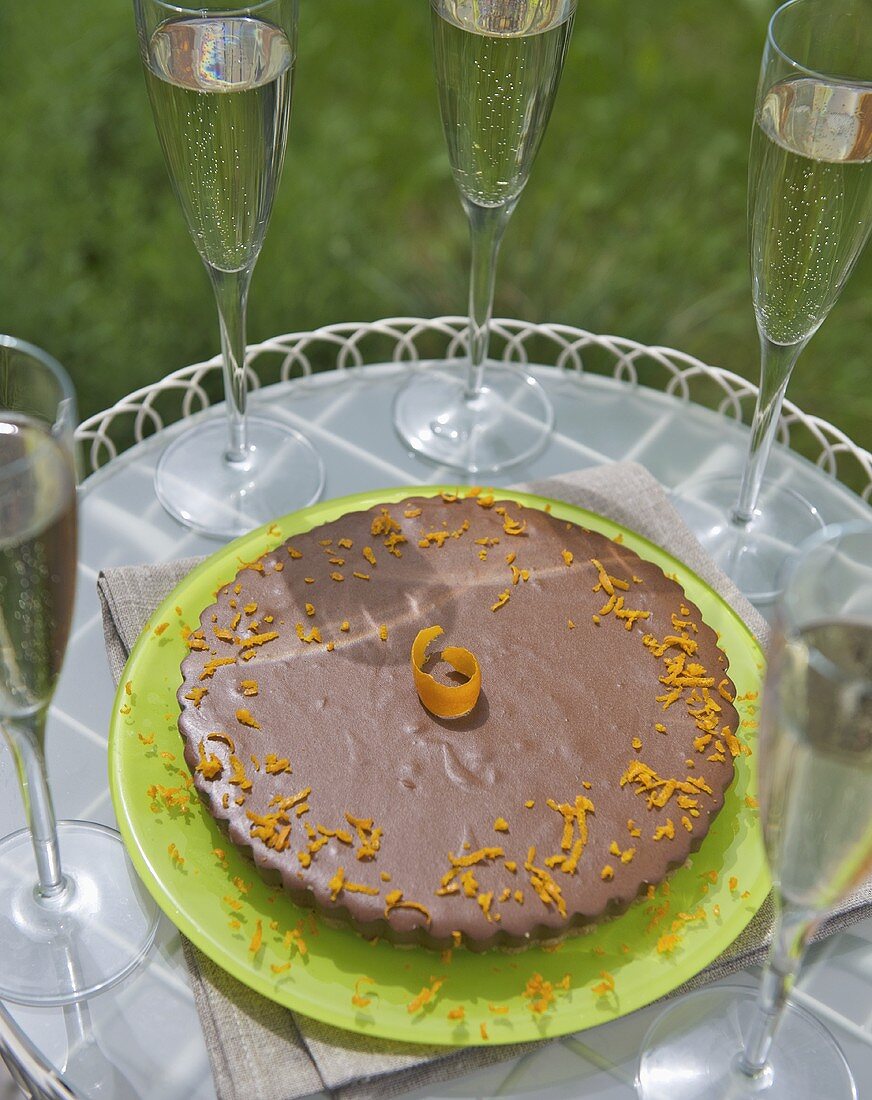 Orange chocolate cheesecake with biscuit base, glasses of wine