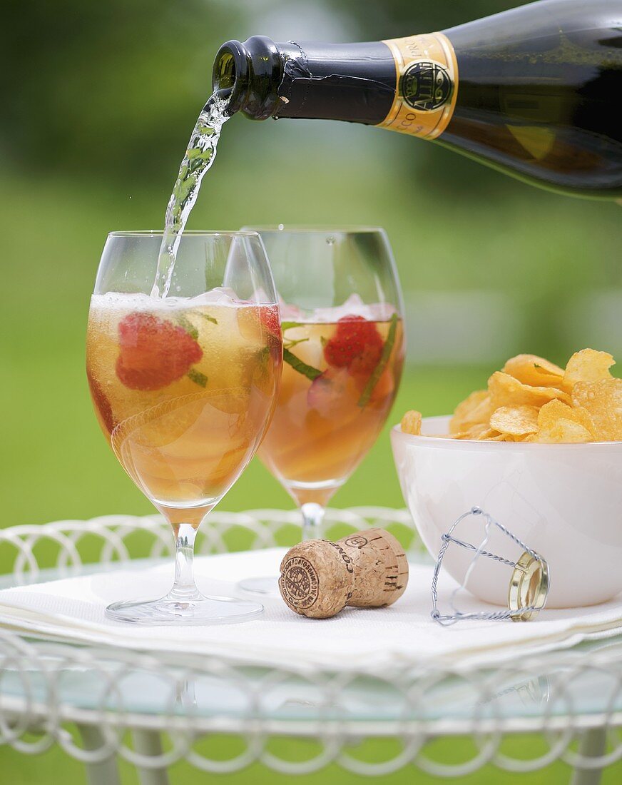 Pimms Cocktail mit Erdbeeren und Minze mit Champagner auffüllen