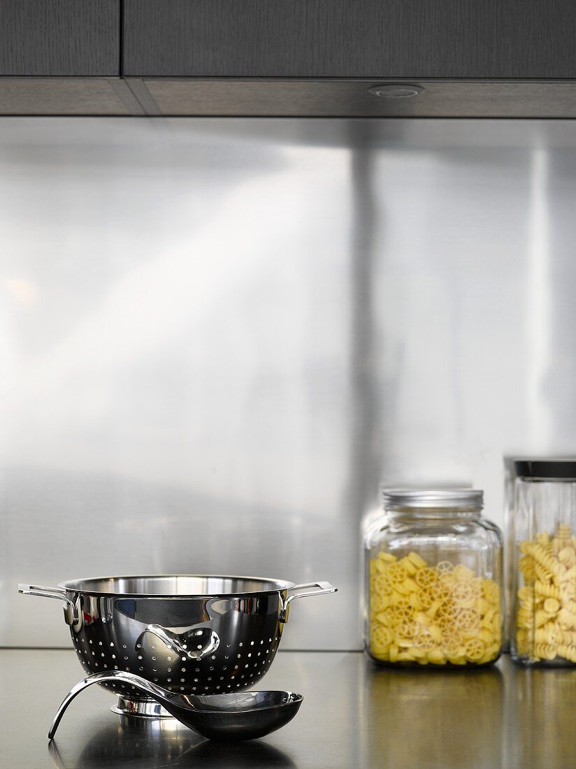 Pasta in jars, stainless steel colander and spoon