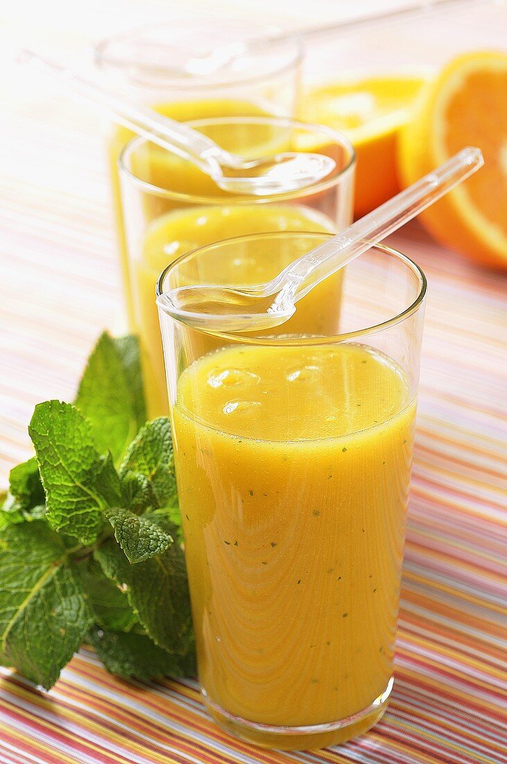 Courgette and orange juice with mint in three glasses