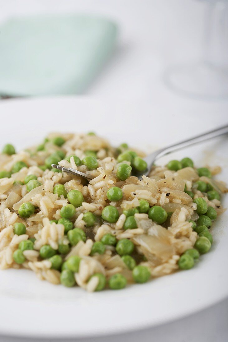A plate of pea risotto with diced onion