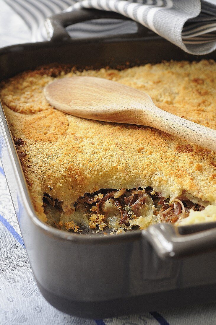 Baked duck and potato dish in a roasting tin