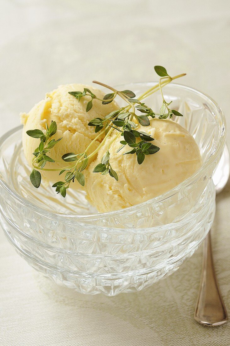 Two scoops of thyme & lemon ice cream in stacked glass dishes