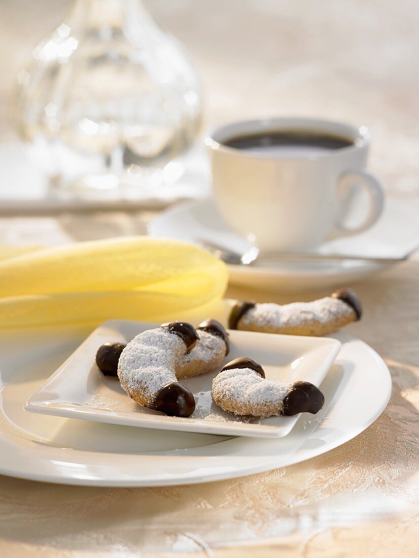 Chocolate-dipped vanilla crescents and a cup of coffee