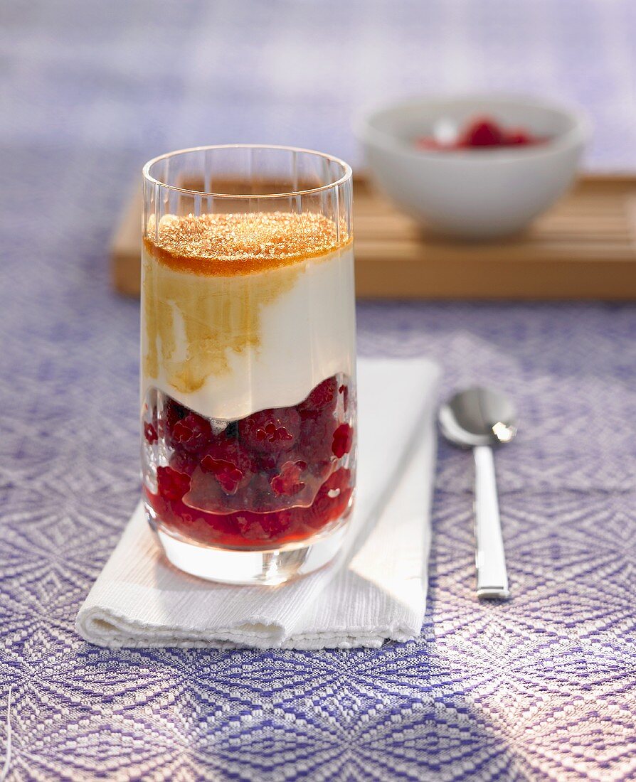 Raspberries with yoghurt cream and cane sugar in a glass