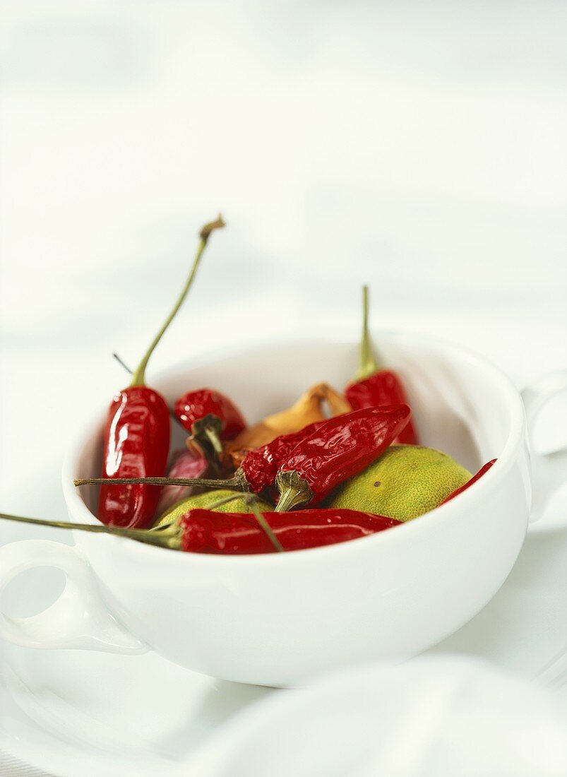 Dried chillies, limes and onion in a porcelain cup