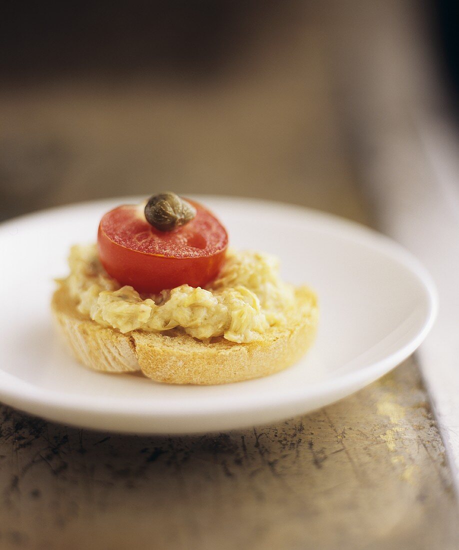 Leek and cheese spread, tomato and caper on crostino