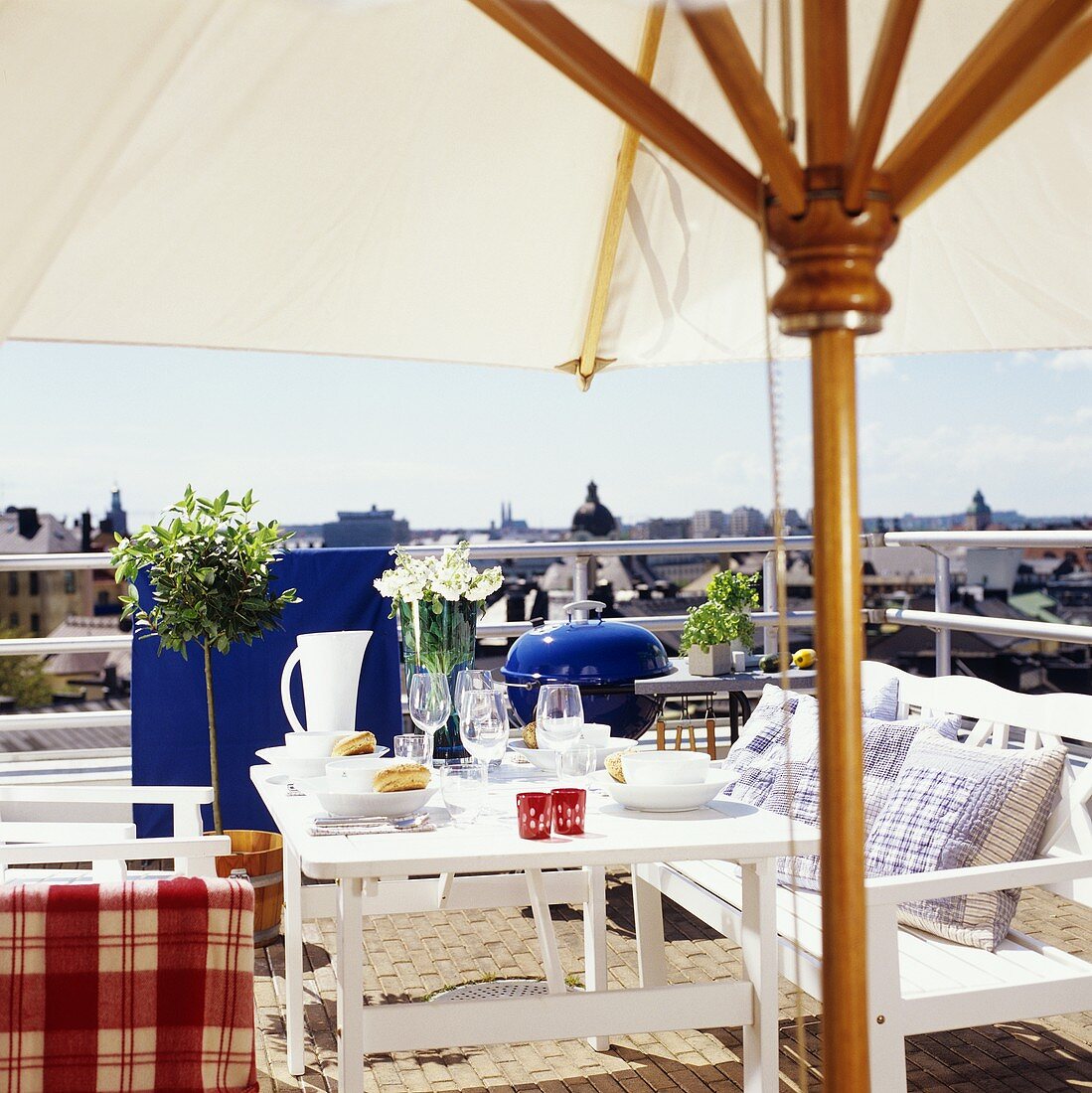 Gedeckter Tisch mit Sonnenschirm auf einem Balkon