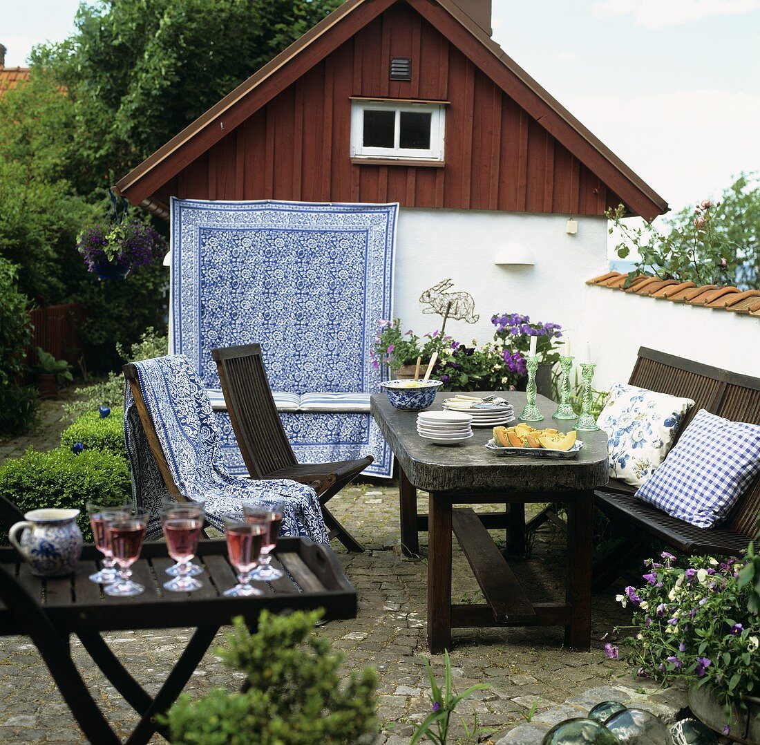 Gedeckter Gartentisch mit Stühlen im Freien