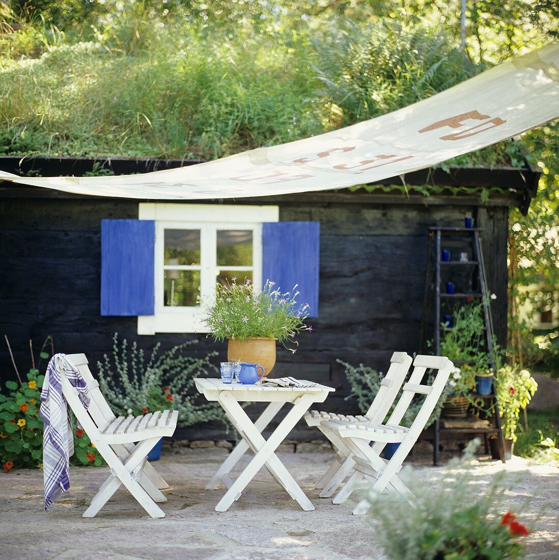 Garden table with chairs and awning out of doors