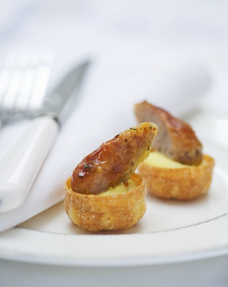 Sausages on mustard mashed potato in shortcrust pastry shells