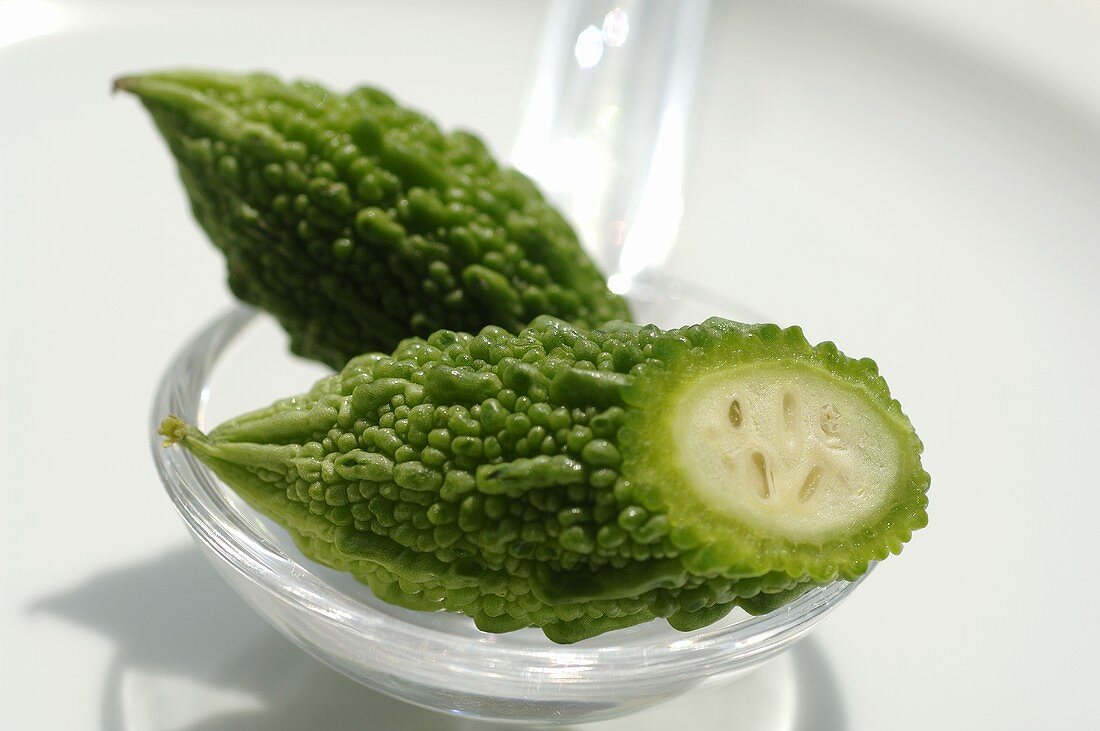 Halved bitter gourd on a spoon