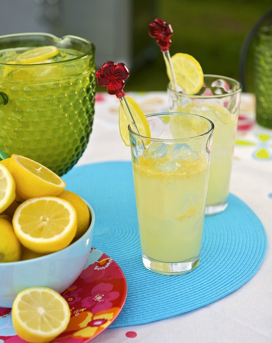 Lemonade with ice cubes in glasses out of doors