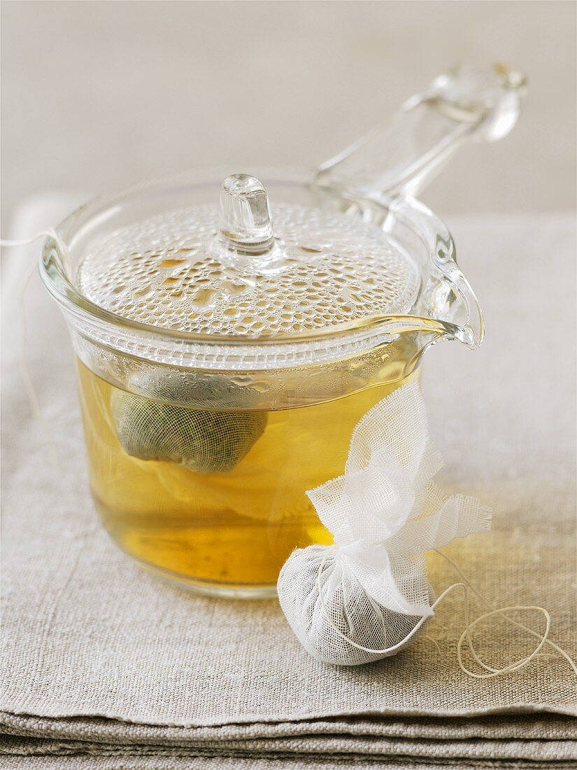 Herbal tea in glass pot and herbs in tea bag
