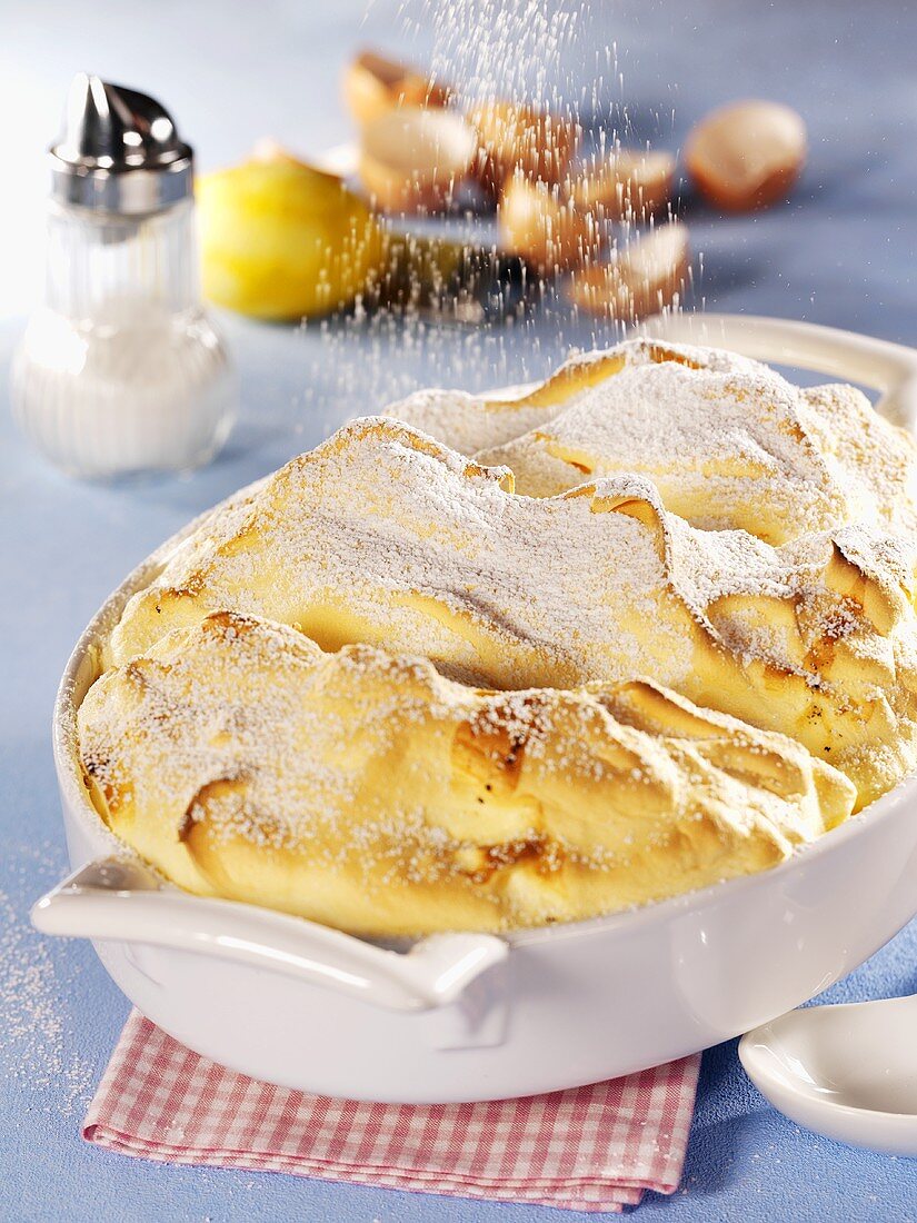 Salzburger Nockerl in der Form mit Puderzucker bestäuben