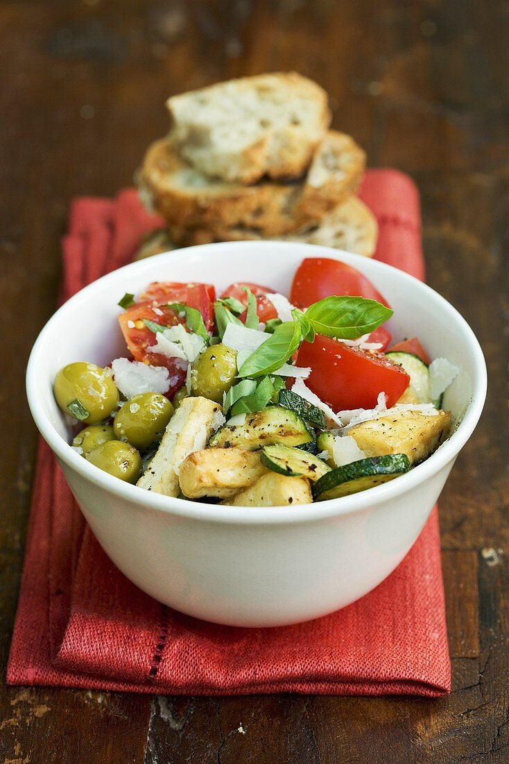 Fried tofu with courgette, olives, tomatoes and Parmesan