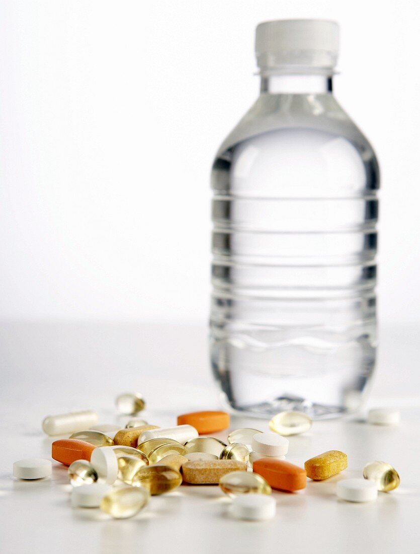 Verschiedene Tabletten vor einer Wasserflasche