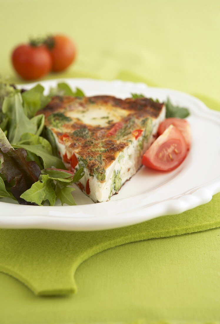 A piece of vegetable frittata with salad leaves