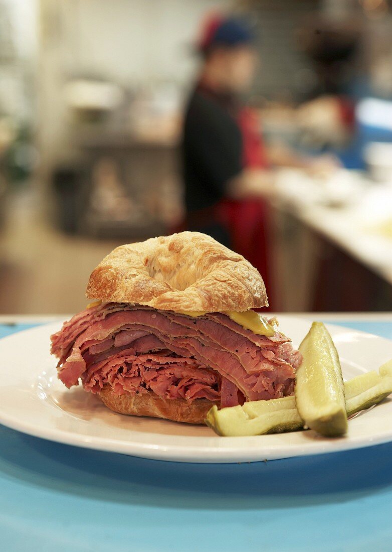 Croissant filled with pastrami and gherkins