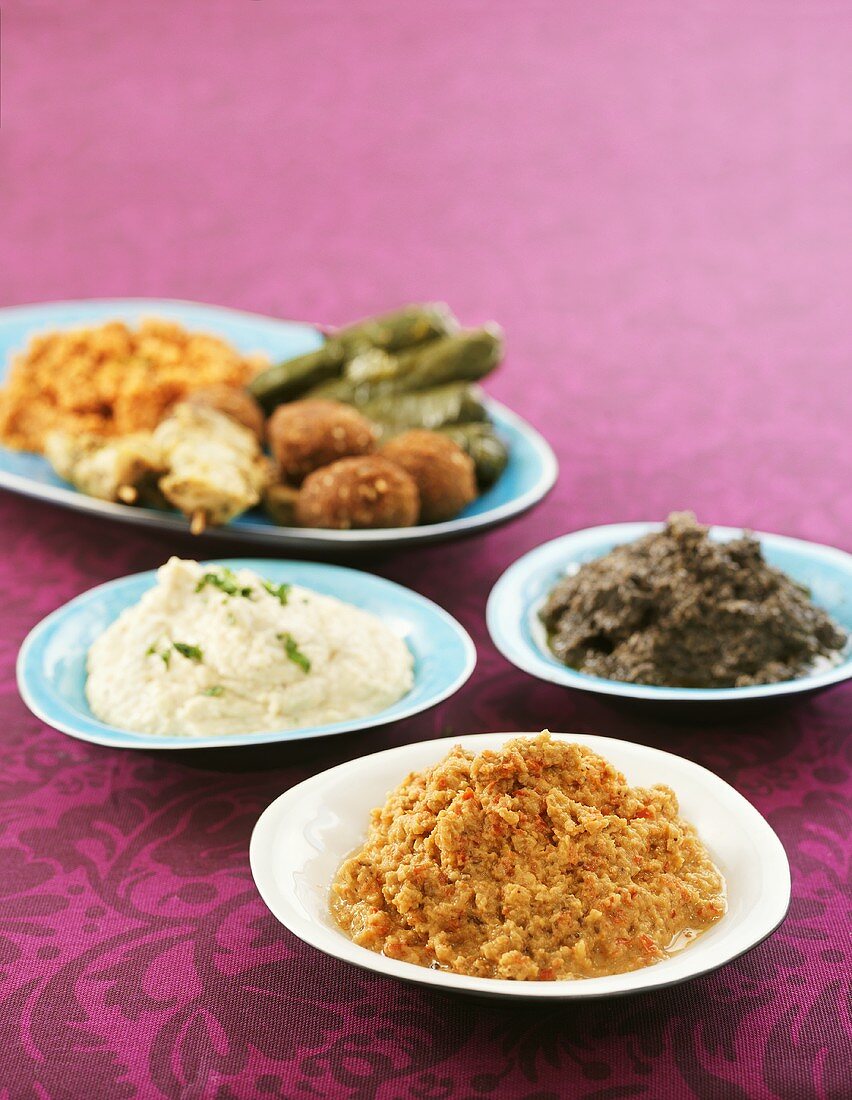 Verschiedene orientalische Vorspeisen auf vier Tellern